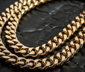 Close-up image of a men's gold chain on a black background