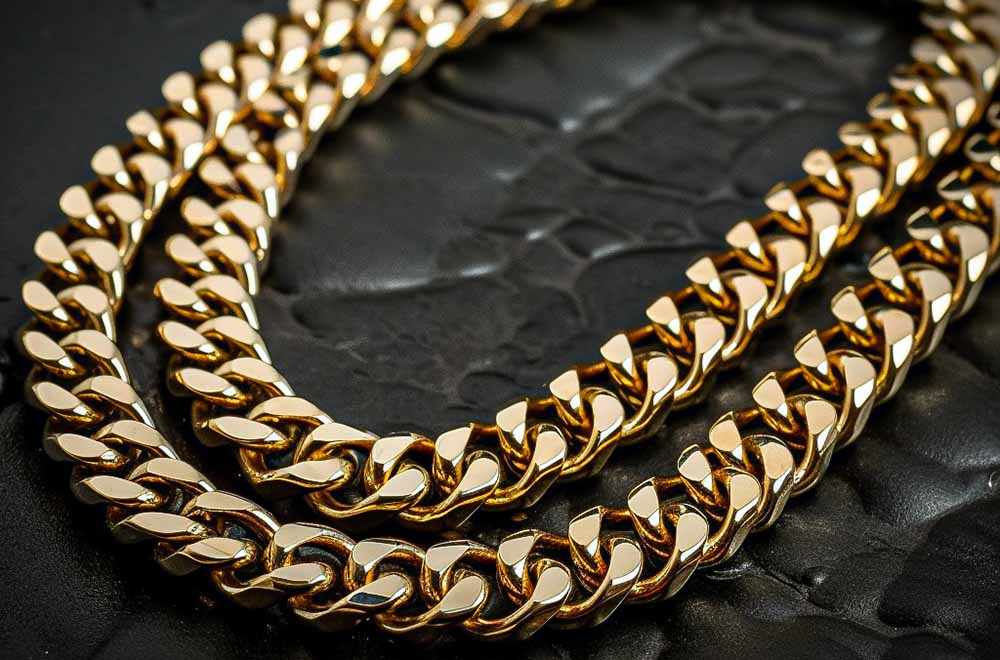 Close-up image of a men's gold chain on a black background